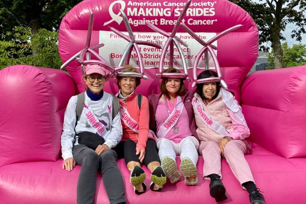 four women sitting on giant pink inflatable chair