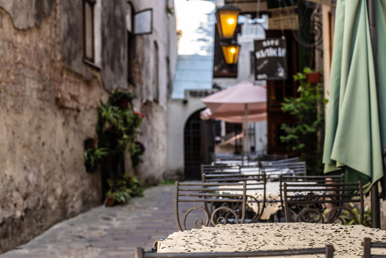 View of old cozy cafe in old city. Wooden tables and chairs in an outdoor cafe